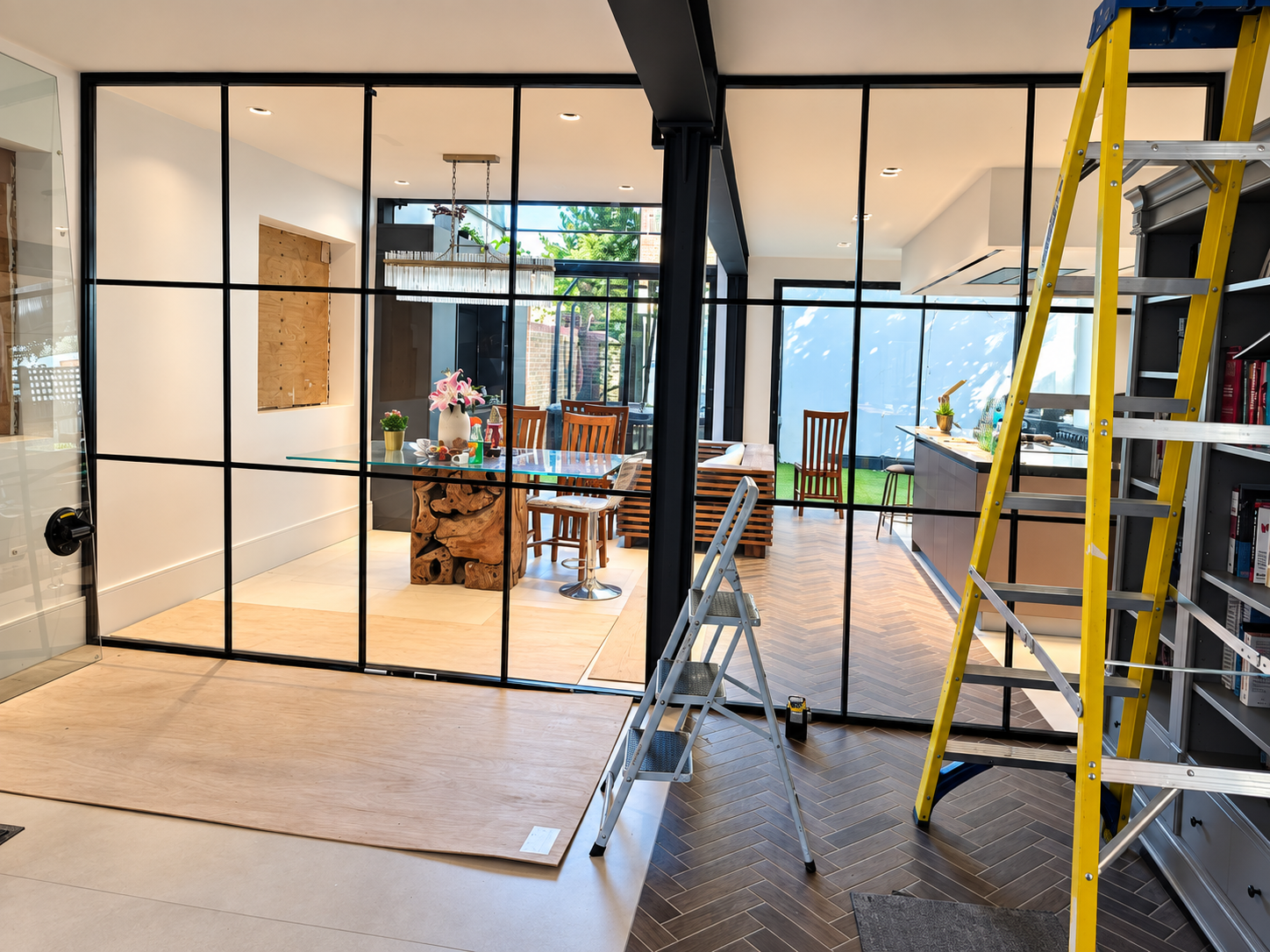 Double-glazed black grid-style partition during installation in Battersea