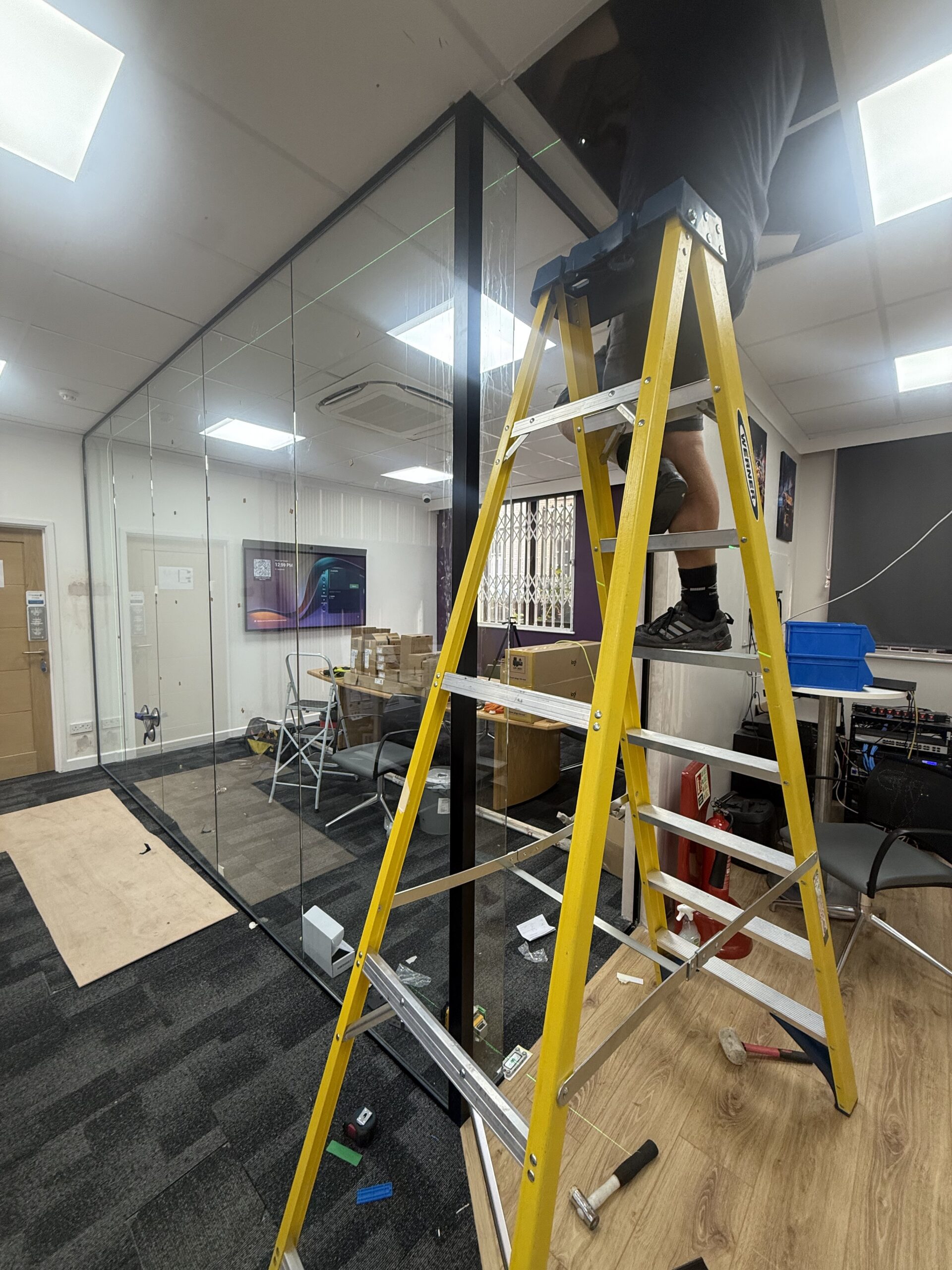 Crittall-style internal glass meeting room with black grid framing in West London