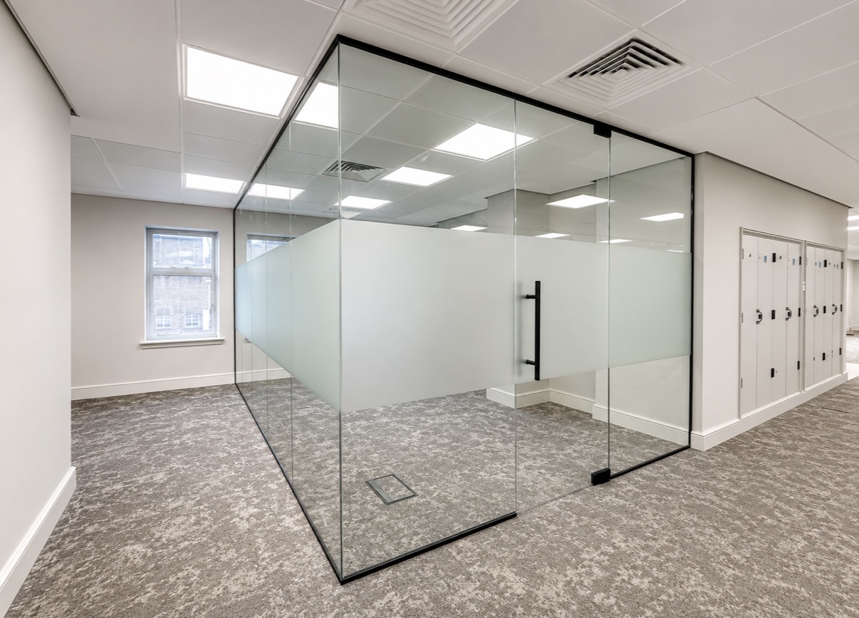 Completed internal glass office partition with black-framed door in Minories London