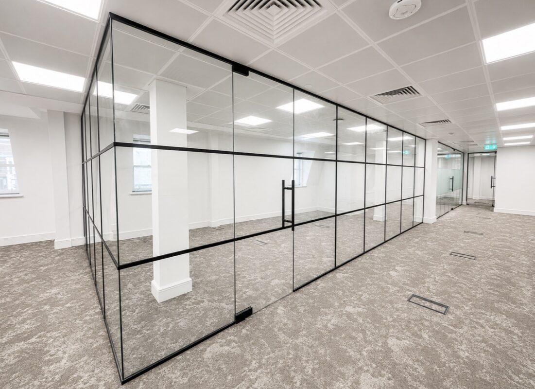 Black framed glass office partition installation in a modern commercial office